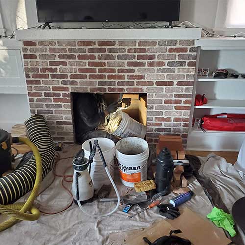 Tucson chimney and Venting Solutions - All kinds of tools everywhere and TV on mantel.